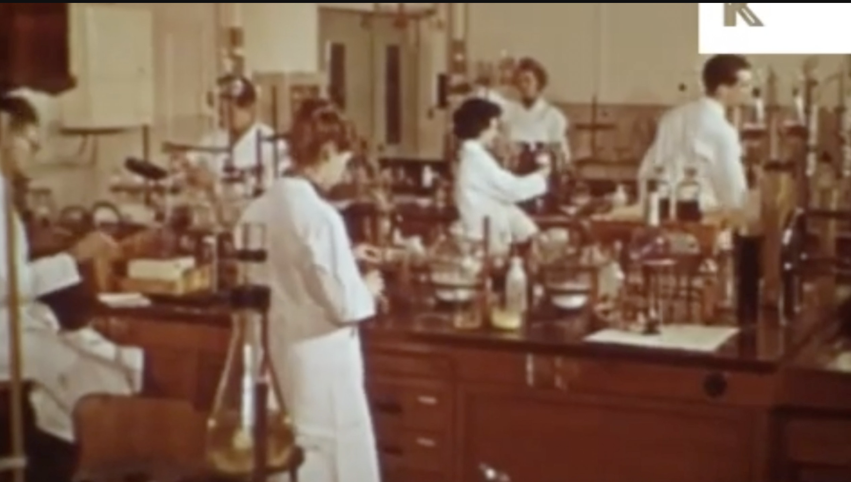 Vintage scientific laboratory with researchers in white coats working at laboratory benches